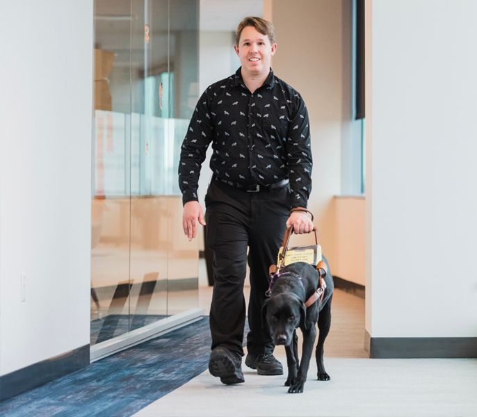 Sight impaired man walking with his seeing eye dog