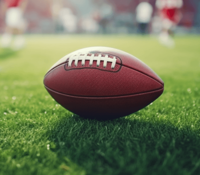 Football sitting on a field, casting shadow